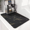 Coffee machine with a black marble-patterned mat on a white countertop
